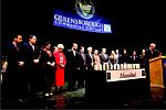 Michael Miller, Exec. Director of JCRC, at the podium asking for a moment of silence for those killed in the Mumbai massacre, as speakers and guests joined him on stage at Queensborough Community College.