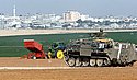 IDF guards Israeli  farmers who are planting potatoes in their fields facing Gaza in background. Photo: Yigal Ben Eliyahu/Jinipix/Israel Sun