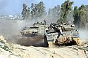 Isareli tanks near the Sufa checkpoint on the Gaza border. In the background where applicable is the Arab town of Khan Yunis. Photo: Eliyahu Ben Yigal/Jinipix/Isreal Sun
